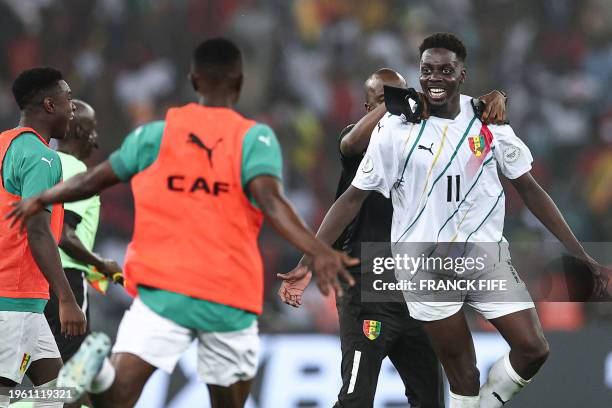 Guinea's midfielder Mohamed Bayo celebrates with teammates after the victory at the end of the Africa Cup of Nations 2024 round of 16 football match...