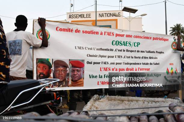 Supporters of the Alliance Of Sahel States hold up their banner as they celebrate Mali, Burkina Faso and Niger leaving the Economic Community of West...