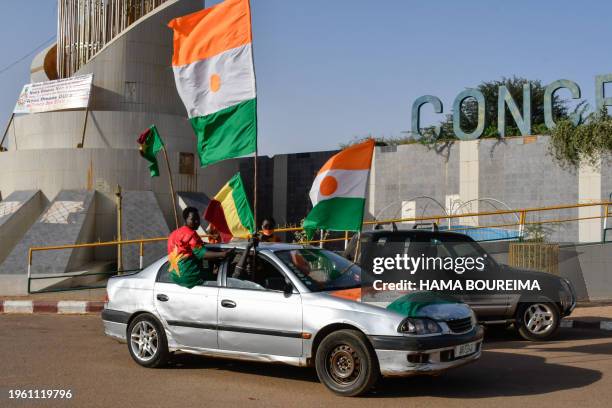 Supporters of the Alliance Of Sahel States drive with flags as they celebrate Mali, Burkina Faso and Niger leaving the Economic Community of West...