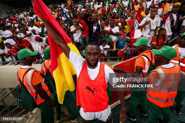 Guinea's midfielder Mory Konate celebrates after the victory at the end of the Africa Cup of Nations 2024 round of 16 football match between...