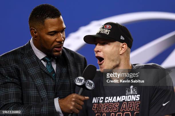 Christian McCaffrey of the San Francisco 49ers celebrates on stage with Fox Sports broadcaster Michael Strahan after defeating the Detroit Lions in...