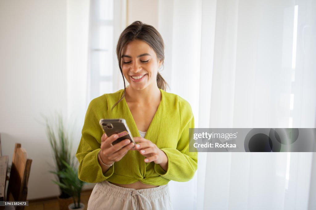 Happy young woman using phone