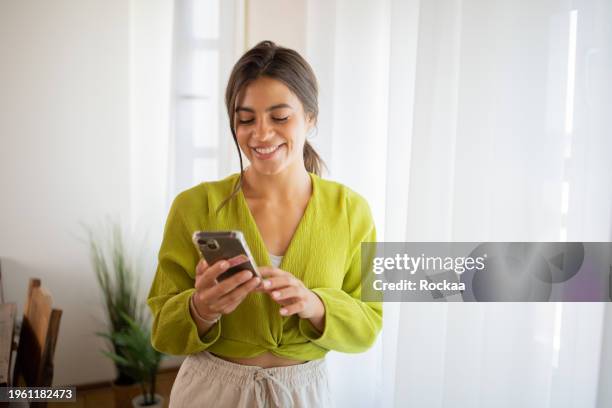happy young woman using phone - latin american and hispanic people stock pictures, royalty-free photos & images
