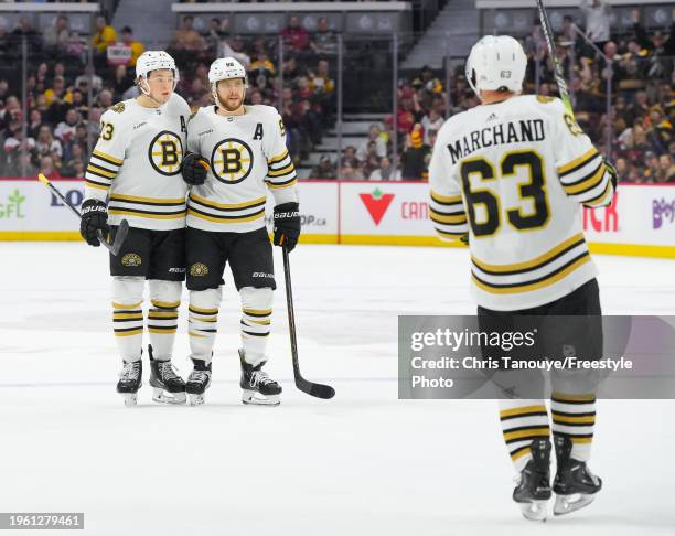 David Pastrnak of the Boston Bruins celebrates his first period goal against the Ottawa Senators with Charlie McAvoy and Brad Marchand at Canadian...