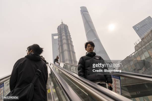 Pedestrians ride escalators in Pudong's Lujiazui Financial District in Shanghai, China, on Monday, Jan. 29, 2024. China will halt the lending of...