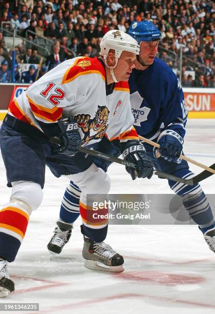 Olli Jokinen of Florida Panthers skates against Joe Nieuwendyk of the Toronto Maple Leafs during NHL game action on December 23, 2003 at Air Canada...
