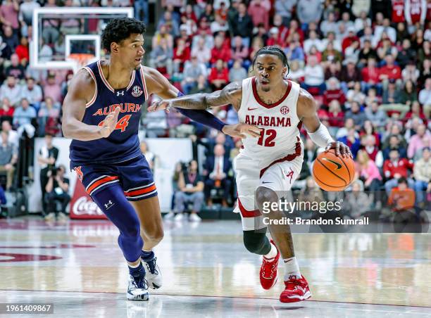 Latrell Wrightsell Jr. #12 of the Alabama Crimson Tide drives to the basket during the second half against Dylan Cardwell of the Auburn Tigers at...
