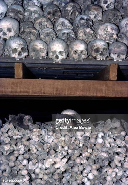 Human remains excavated from a mass gave at the Killing Fields of Choeung Ek sit stacked in a simple open-air hut. Many of the dead were former...