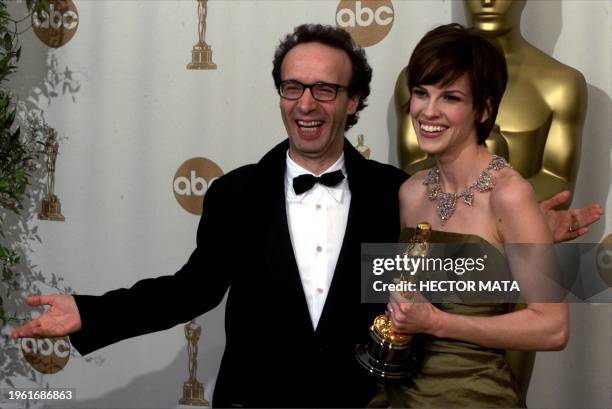 Actress Hilary Swank holds her Oscars for Best Actress for her role in "Boys Don't Cry" with Italian actor and the award's presenter, Roberto Benigni...