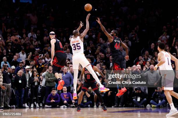 Kevin Durant of the Phoenix Suns hits the go ahead three pointer over Alex Caruso of the Chicago Bulls and Patrick Williams during the game at...