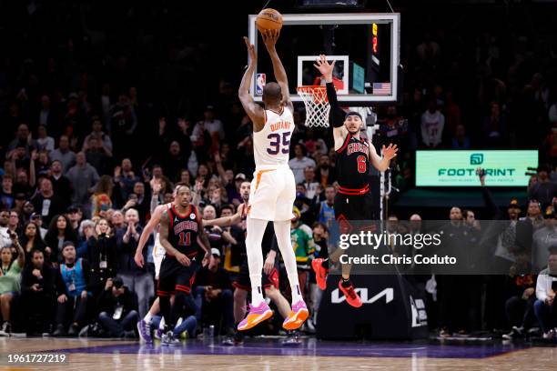 Kevin Durant of the Phoenix Suns attempts a three point shot over Alex Caruso of the Chicago Bulls during the game at Footprint Center on January 22,...