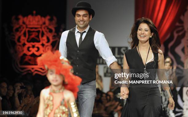 Indian actor Abhay Deol and Indian designer Ritu Beri walk on the catwalk during Beri's show at the Wills India Fashion Week presenting Spring Summer...