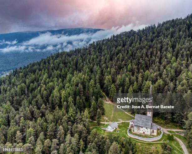 aerial view, high mountain landscape in the dolomite alps with a typical church in a valley. - bernat bacete stock pictures, royalty-free photos & images