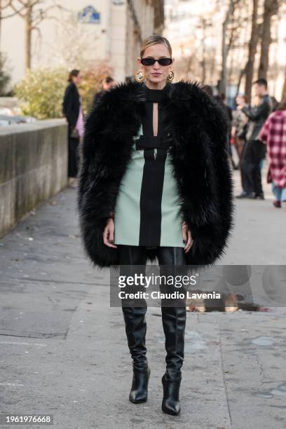 Helena Bordon wears teal mini dress with black bow details, black fur coat, black over the knees boots, outside Elie Saab, during the Haute Couture...