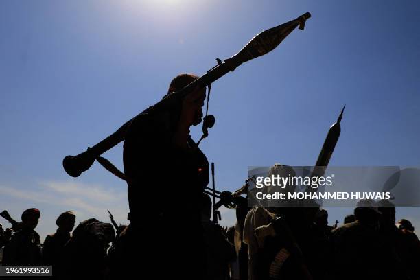 Armed supporters of Yemen's Huthi rebels attend a rally in solidarity with the Palestinian Hamas movement's armed resistance against Israel in the...