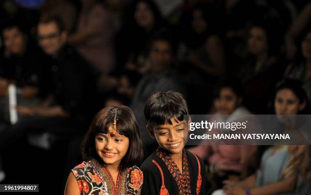 'Slumdog Millionaire' child actors Mohammed Azharuddin Ismail and Rubina Ali Qureshi walk the ramp while presenting creations by Indian designers...
