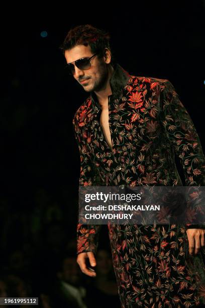 Indian film actor John Abraham presents a creation by Indian designer Rohit Bal on April 5 during the grand finale of the Kolkata Fashion Week in...