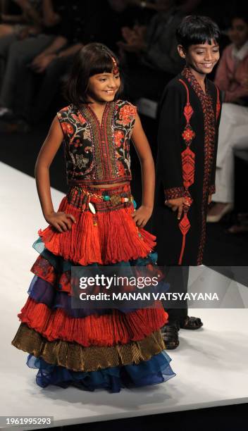 'Slumdog Millionaire' child actors Mohammed Azharuddin Ismail and Rubina Ali Qureshi walk the ramp while presenting creations by India designers...
