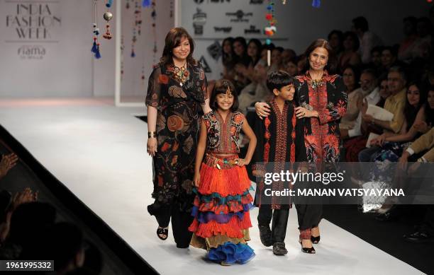 Indian designers Ashima and Leena accompany 'Slumdog Millionaire' child actors Mohammed Azharuddin Ismail and Rubina Ali Qureshi as they walk the...