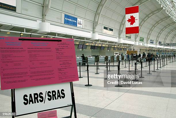 Health Canada Notice about Severe Acute Respiratory Syndrome stands in Terminal 3 at Toronto's Pearson International Airport April 30, 2003. With...