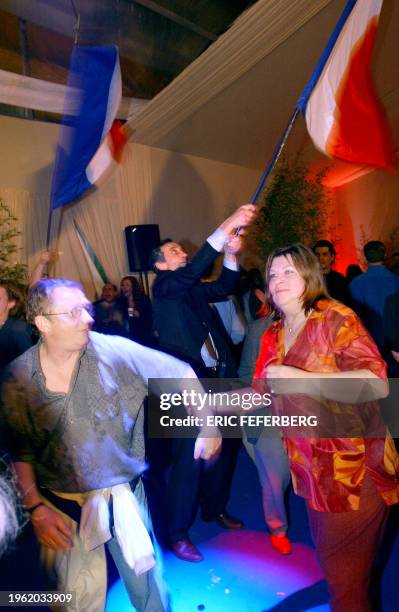 Des militants du Front National réagissent après l'annonce des premières estimations des résultats du premier tour des élections, le 21 avril 2002 à...