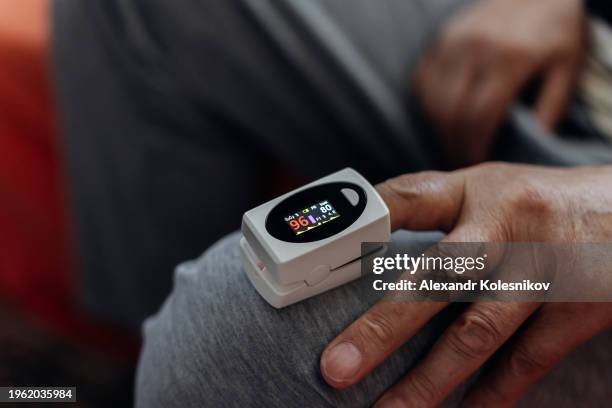 close up of a hand with a pulse oximeter on the finger. pulse oximeter finger digital device to measure oxygen saturation in blood and pulse rate. - kazakhstan coronavirus stock pictures, royalty-free photos & images