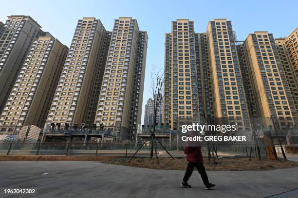 Woman walks past an Evergrande Group residential complex called Evergrande Palace in Beijing on January 29, 2024. A Hong Kong court on January 29...