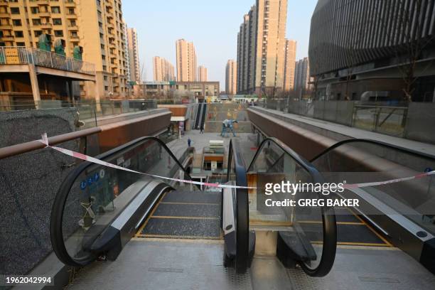 Blocked off escalator is seen at a partially operating Evergrande commercial complex in Beijing on January 29, 2024. A Hong Kong court on January 29...