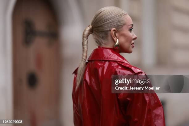 Sasha Ray seen wearing Bottega Veneta gold earrings, red high neck knit top, red varnished leather long coat, before Gaurav Gupta, during the Haute...