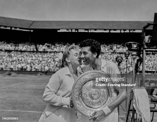 American tennis player Althea Gibson holding her trophy after after defeating Darlene Hard , also of the United States, in the women's final at the...