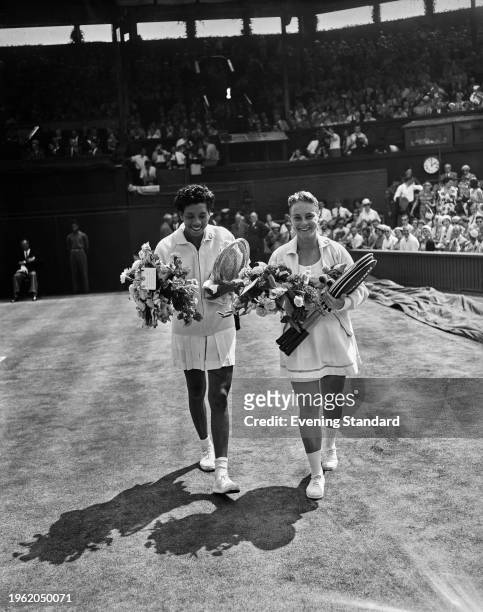 American tennis players Althea Gibson and Darlene Hard holding bouquets before their women's singles final at the Wimbledon Tennis Championships in...
