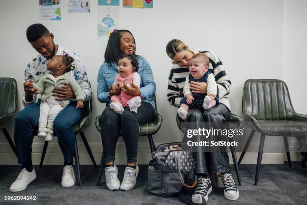 waiting patiently at the baby clinic - community center stock pictures, royalty-free photos & images