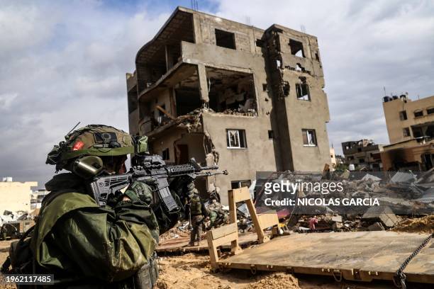 This picture taken during a media tour organised by the Israeli military on January 27 shows an Israeli soldier aiming his weapon in front of a...