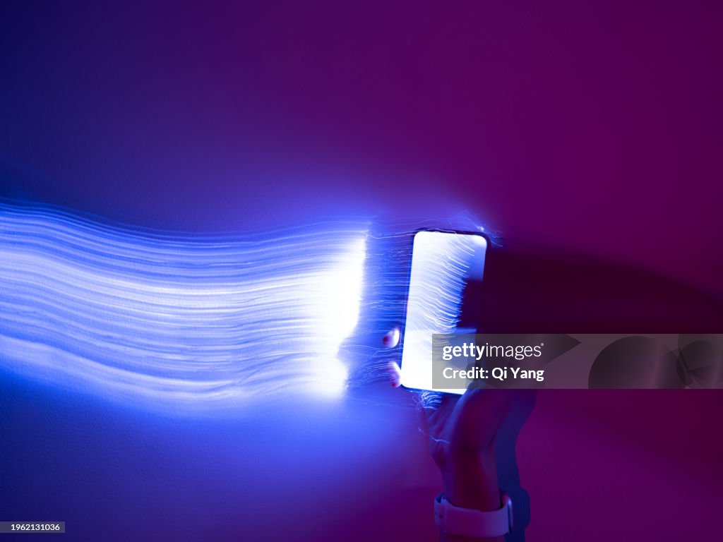 Close-up of using mobile phone on holographic background
