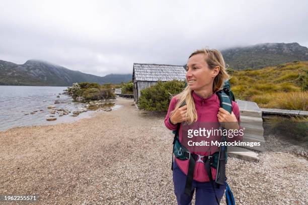 ruhe am ufer: eine wanderin erreicht den seestrand und genießt die ruhe des naturparadieses - hiking tasmania stock-fotos und bilder