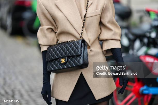 Angela Gonzalez wears a beige oversized blazer jacket black gloves, a leather Chanel bag, outside Ashi Studio, during the Haute Couture Spring/Summer...