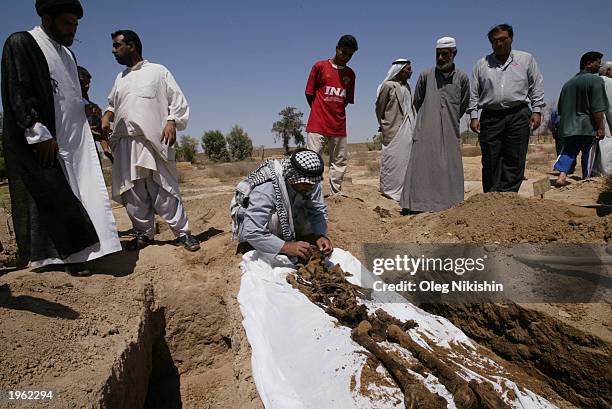 An Iraqi man exhumes the remains of his brother at a cemetery for political victims of Saddam Hussein's regime April 30, 2003 in Abu Ghraib, 35...