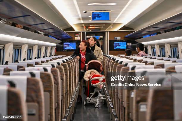 Travelers get on a train at Guangzhounan Railway Station on the first day of China's Spring Festival travel rush on January 26, 2024 in Guangzhou,...