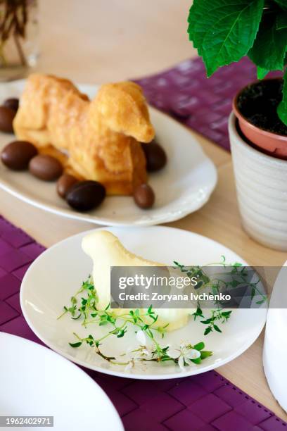 butter in the shape of a lamb on a set easter table - lammetje stockfoto's en -beelden