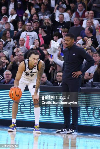 Providence Friars guard Devin Carter stands by Providence Friars head coach Kim English as he dribbles out the game clock in the closing seconds of...