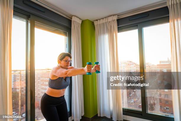 mature woman exercising at home in the morning - exercício anaeróbico imagens e fotografias de stock