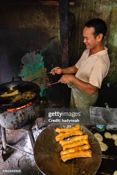 burmese man preparing and selling fresh chinese doughnuts, myanmar - youtiao stock pictures, royalty-free photos & images