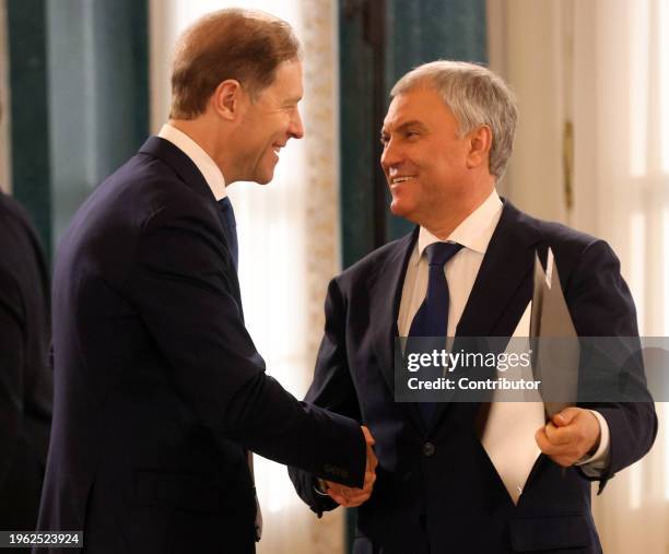 Russian State Duma Chairman Vyachslav Volodin shakes hands with Deputy Prime Minister Denis Manturov during the plenary session of the Supreme...