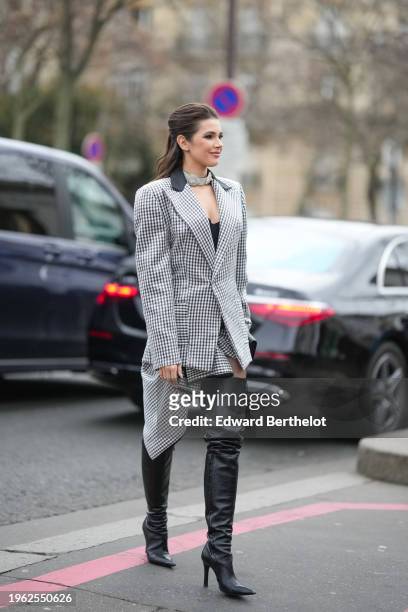 Guest wears a choker, a black and white checkered oversized blazer jacket worn as a dress, thigh high leather pointed high heels boots, outside...