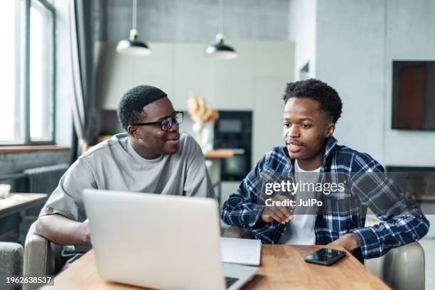 zwei junge erwachsene schwarze männliche studenten machen hausaufgaben mit einem laptop - male student wearing glasses with friends stock-fotos und bilder