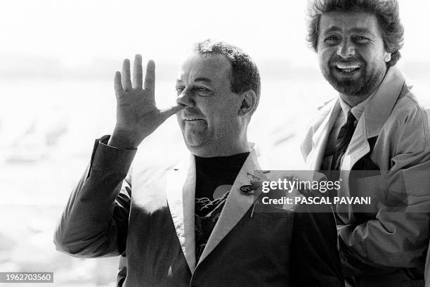 French actor Coluche makes faces on May 18, 1985 while Italian actor Beppe Grillo laughs during the 38th International Cannes Film Festival, where...