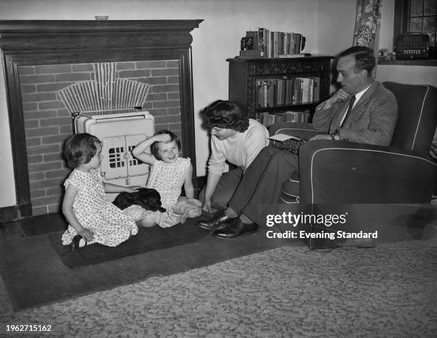 British writer David Beaty at home with his wife Betty, their daughters and a puppy, June 20th 1956.