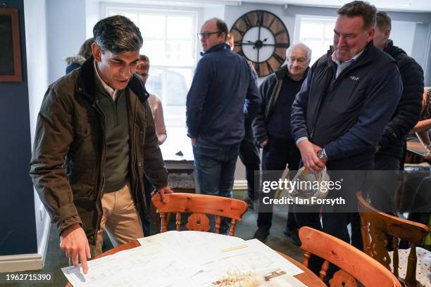 Prime Minster Rishi Sunak looks at building plans as he visits Corn Mill Tearoom in the village of Bainbridge to meet constituents involved with the...