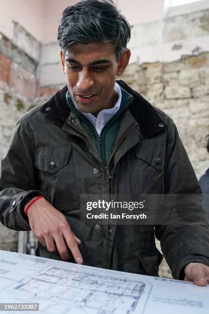 Prime Minster Rishi Sunak views building plans as he visits the village of Bainbridge to meet constituents involved with the renovation of a former...