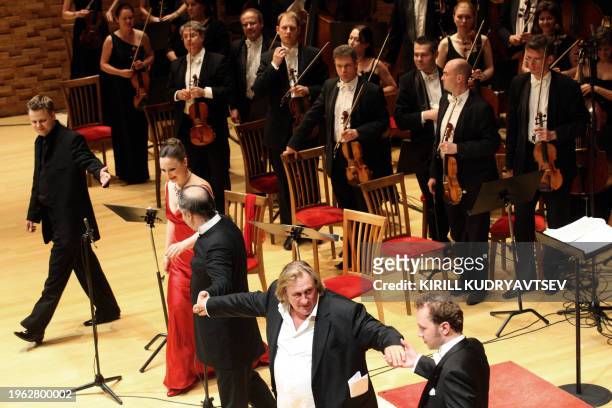 Famous French actor Gerard Depardieu joins hands with other performers to acknowledge applauds from the audience on the stage of Mariinsky Theatre in...